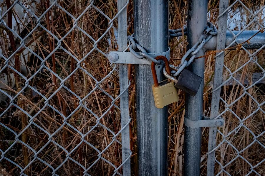 A chain and padlock securing a site perimeter gate