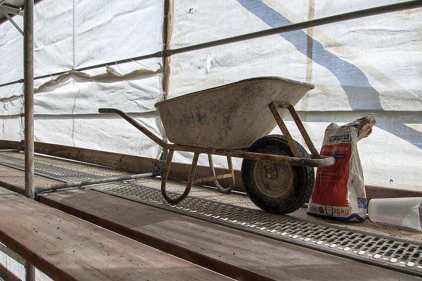 A wheelbarrow parked on a temporary site ramp